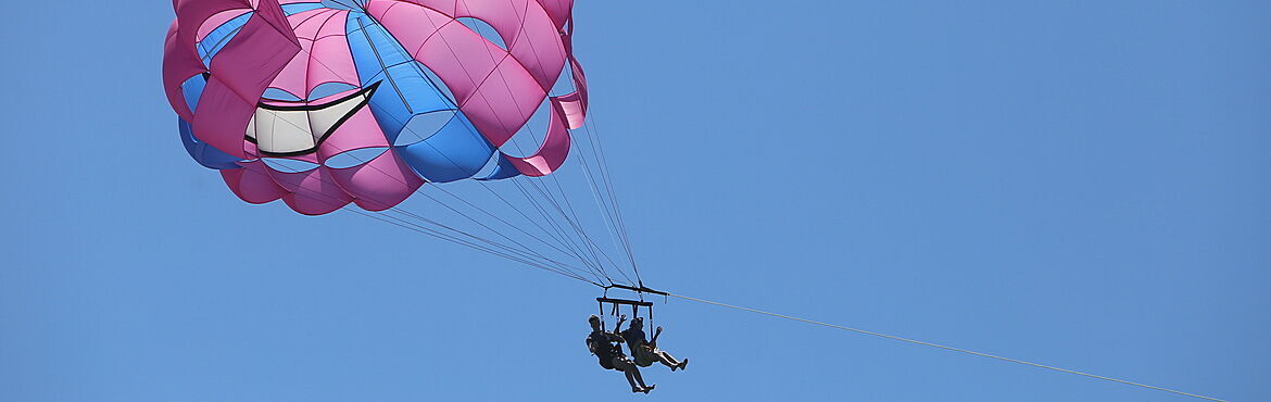 Pink parasail with two people aboard